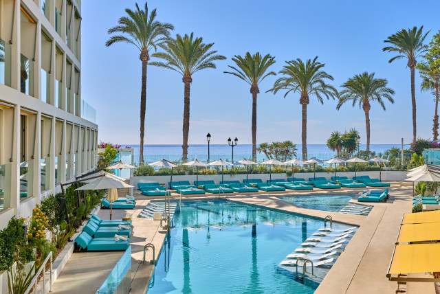 view of hotel pool with palm trees in the background