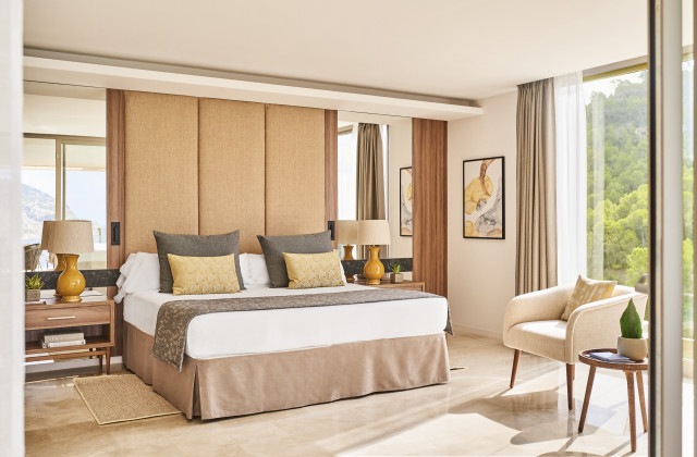 hotel bedroom with soft, netural tones and fabric headboard
